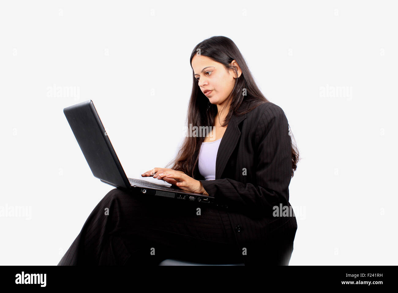 A beautiful Indian business woman using a laptop, on white studio ...