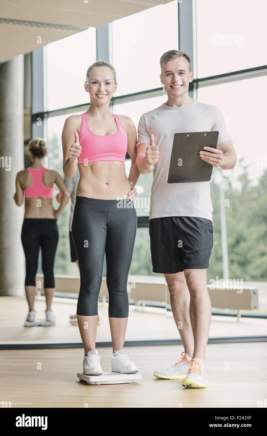 smiling man and woman with scales in gym Stock Photo Alamy