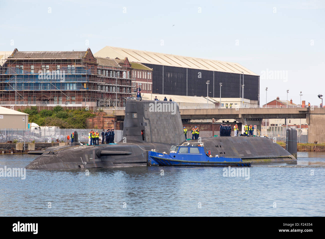 The Artful an Astute class hunter killer nuclear powered submarine is moved from BAE Systems in Barrow in Furness up to the Faslane submarine base in Scotland, UK. In the background is the nuclear transport ship, The Heron.  The submarines are armed with Spearfish torpedoes and Tomahawk Cruise missiles. Stock Photo