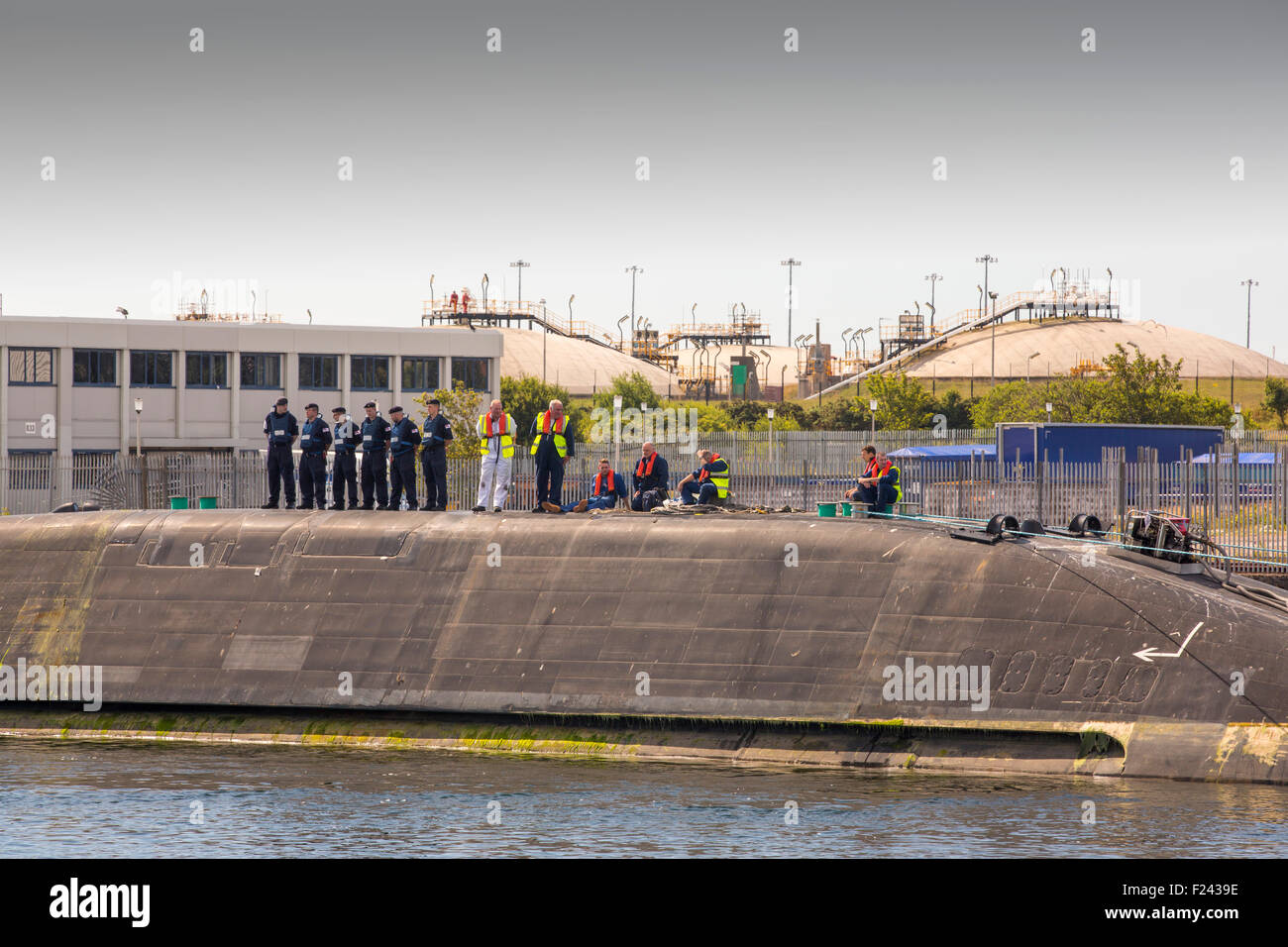 The Artful an Astute class hunter killer nuclear powered submarine is moved from BAE Systems in Barrow in Furness up to the Faslane submarine base in Scotland, UK. The submarines are armed with Spearfish torpedoes and Tomahawk Cruise missiles. This shot shows gas condensate storage tanks in the background. Stock Photo