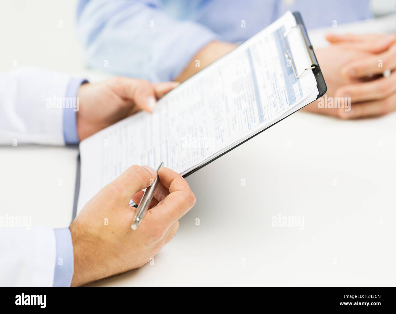 close up of male doctor and patient with clipboard Stock Photo - Alamy