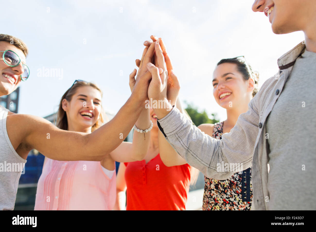 close up of happy friends making high five gesture Stock Photo