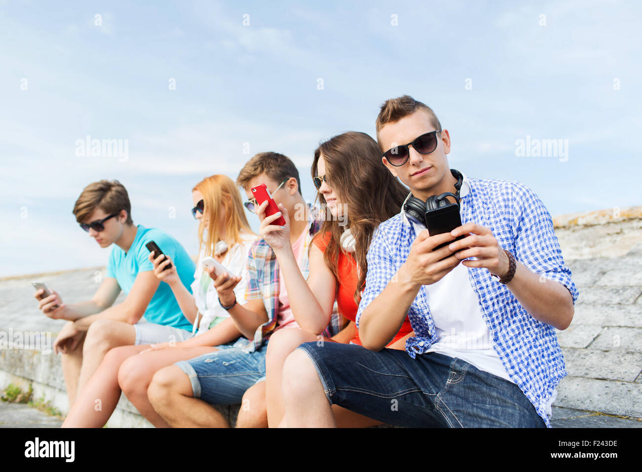 group of friends with smartphone outdoors Stock Photo