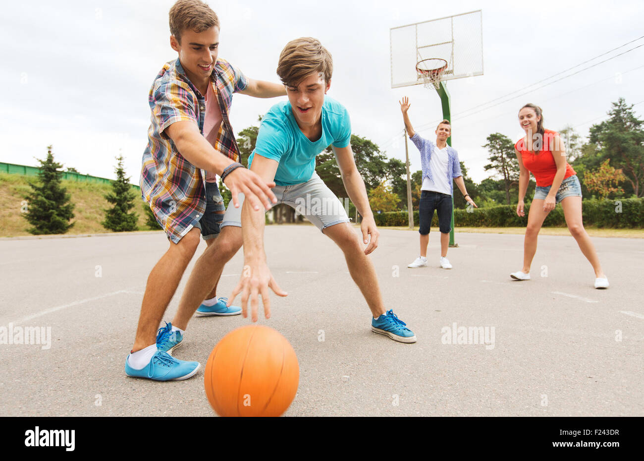 group of happy teenagers playing basketball Stock Photo - Alamy