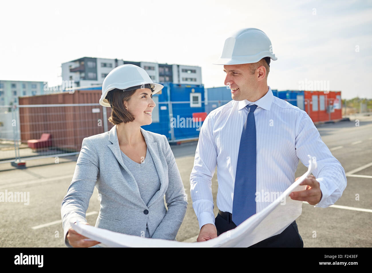 happy architects with blueprint at building Stock Photo - Alamy