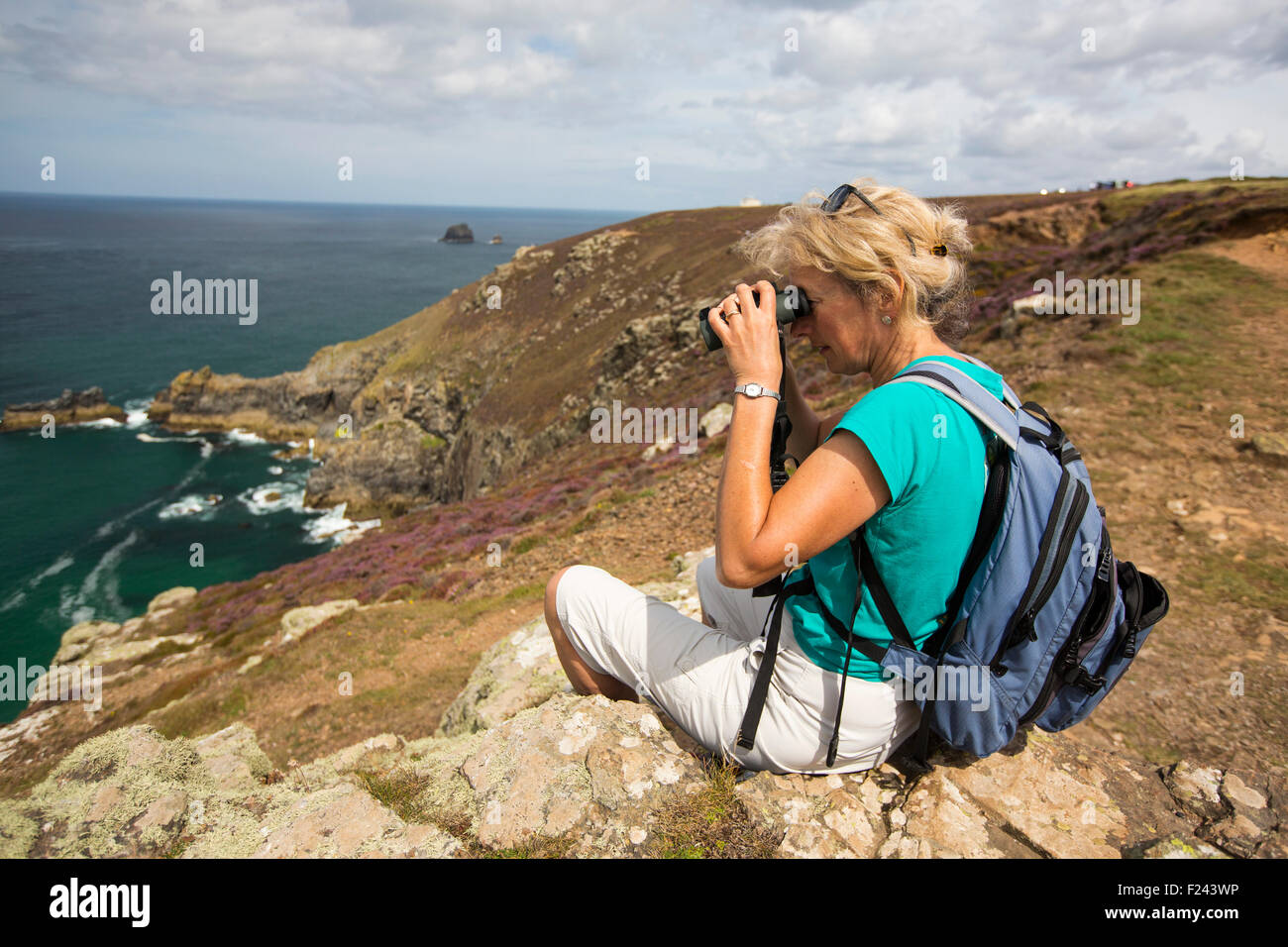 A woman sea watching on the cliffs at St Agnes, Cornwall, UK. Stock Photo
