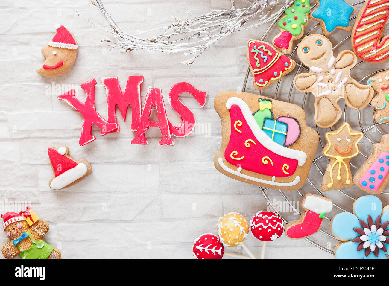 Christmas baking. Various types of Christmas decorative cookies decorated with sugar icing on cooling rack and XMAS letters Stock Photo