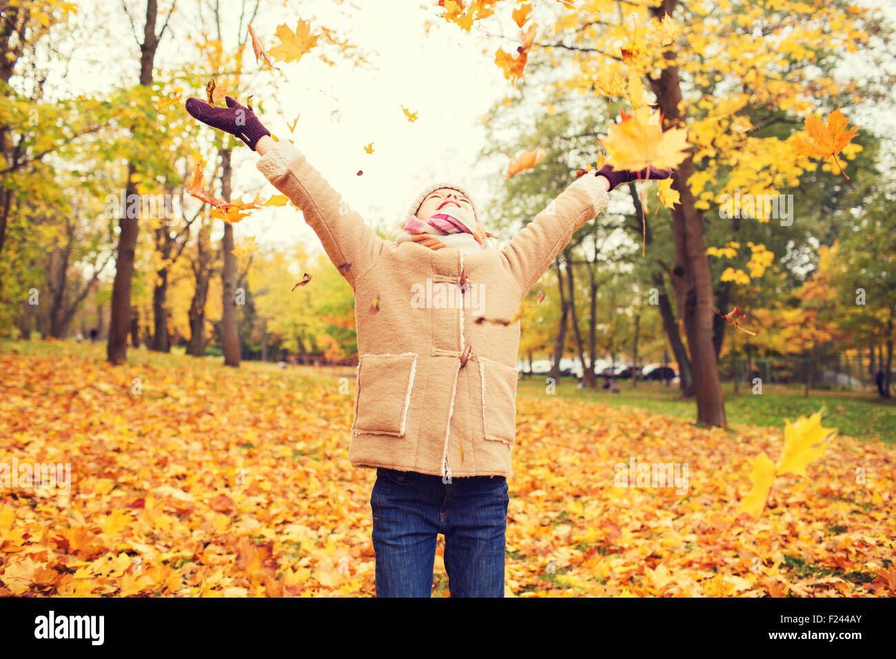smiling little girl with autumn leaves in park Stock Photo - Alamy