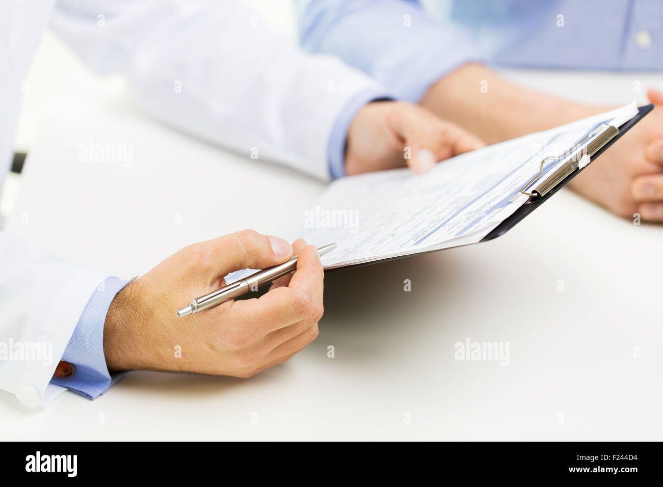 close up of male doctor and patient with clipboard Stock Photo - Alamy