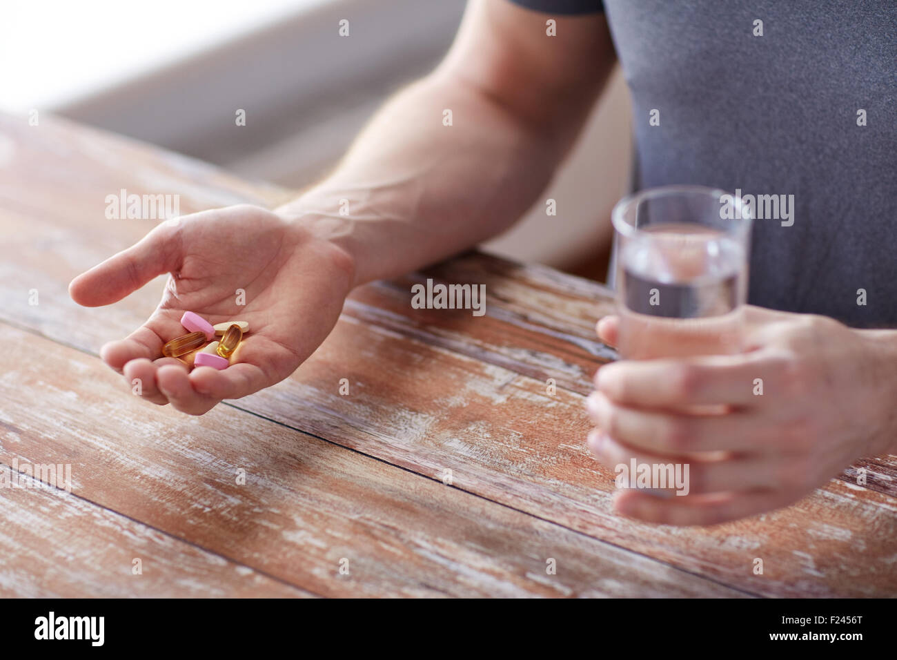 close up of male hands holding pills and water Stock Photo