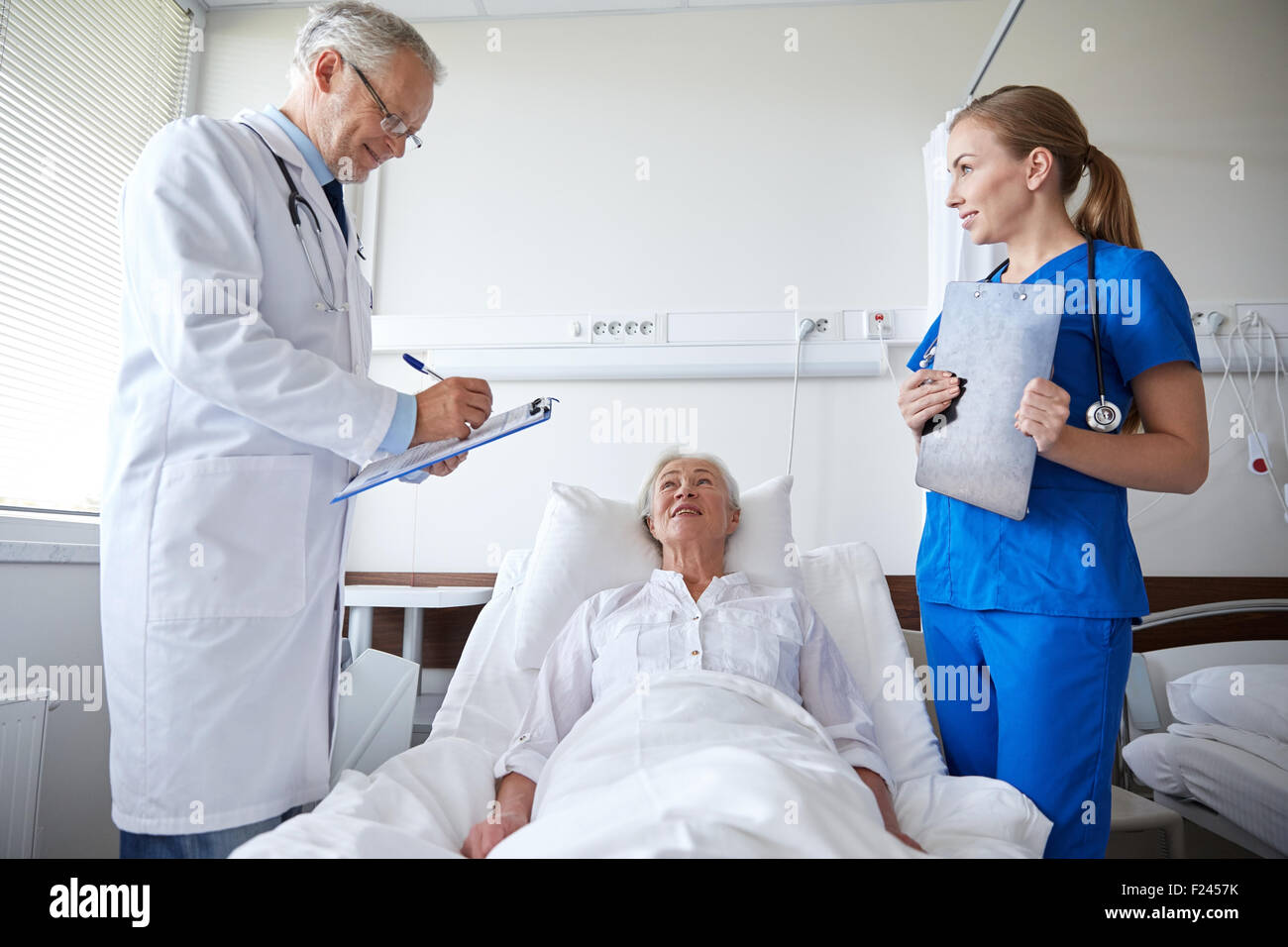 doctor and nurse visiting senior woman at hospital Stock Photo - Alamy