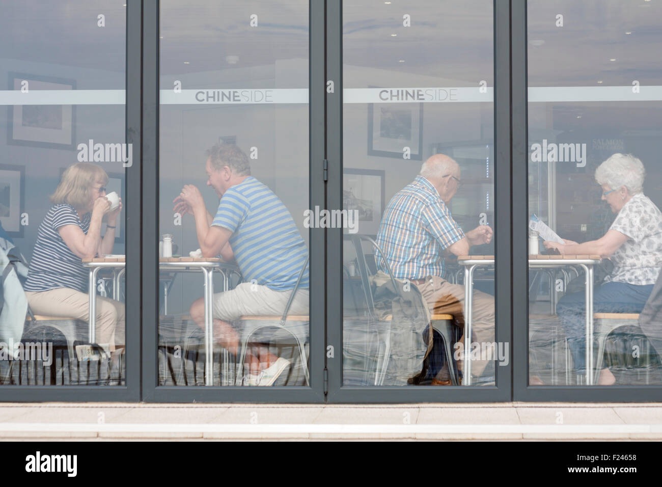 Visitors enjoy a cuppa at the new Chineside restaurant at Durley Chine seafront, Bournemouth in September Stock Photo