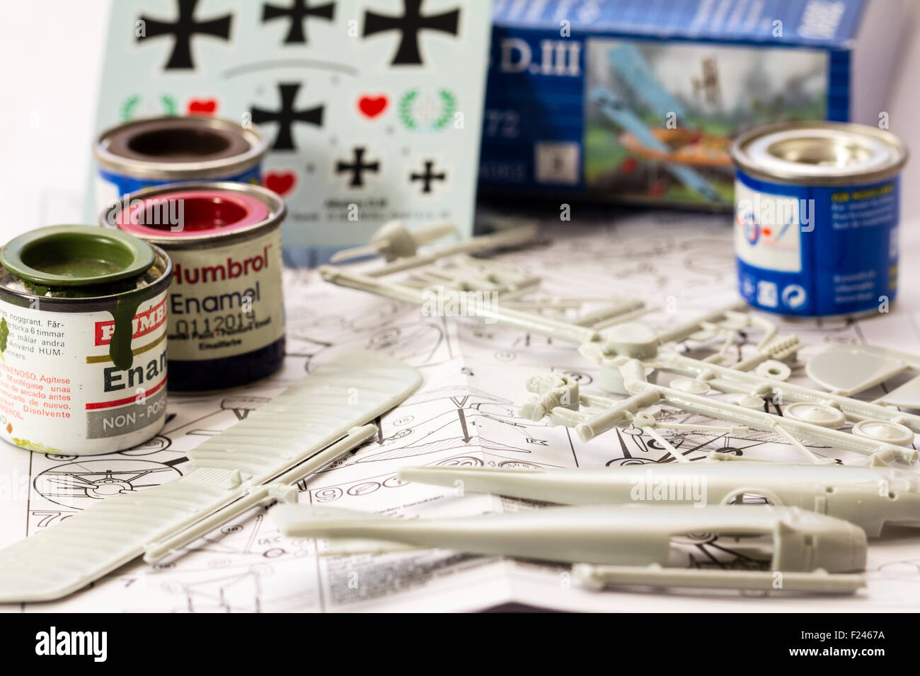 Revell World War one plastic model aircraft kit, instruction sheet background, spurs with parts on, tins of modelling paint and transfer, decal sheet. Stock Photo