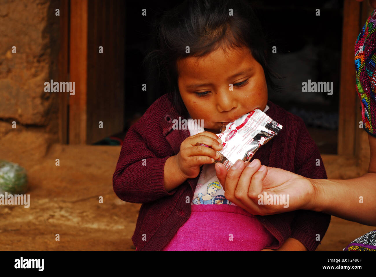 Guatemala, San Bartolo, plumpy nut pack eaten by little indigenous girl (Orbelina Nataly Sontay Ramirez 3) Stock Photo
