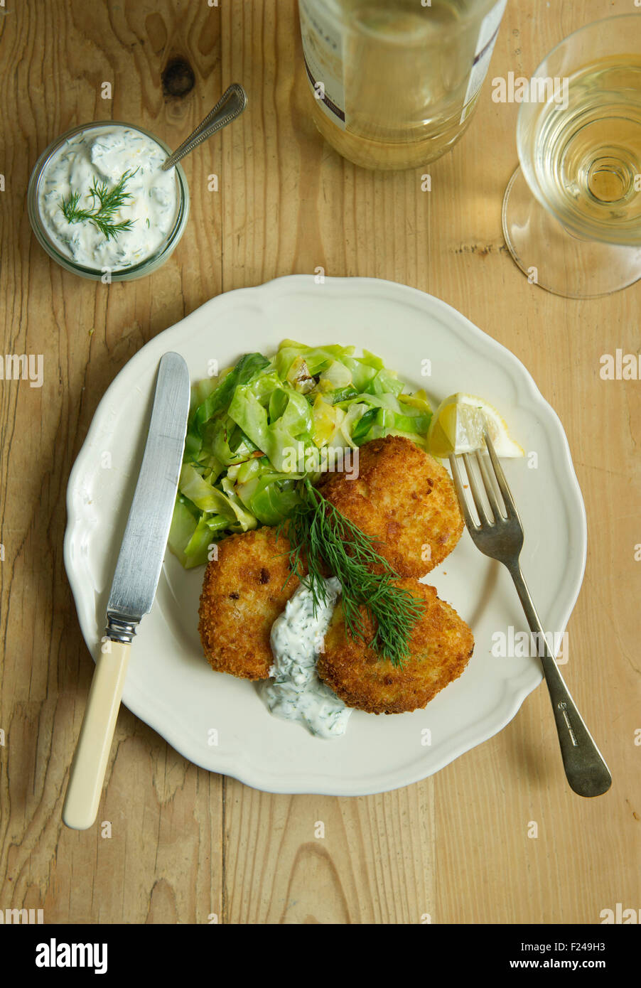 Spiced fishcakes with spring cabbage and tartare sauce. a UK meal cuisine seafood fish meal meals dish small plate eat eating Stock Photo