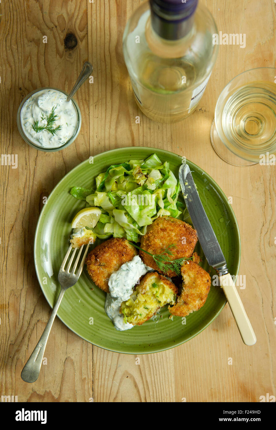 Spiced fishcakes with spring cabbage and tartare sauce. a UK meal cuisine seafood fish meal meals dish small plate eat eating Stock Photo