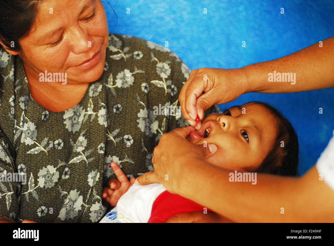 Guatemala, San Juan Chamulco, baby in hands of mother while giving vitamine A (Mercedes Andrea Tzub Chen 36, Angela Andrea Tun Tzub 3 years 11 months) Stock Photo
