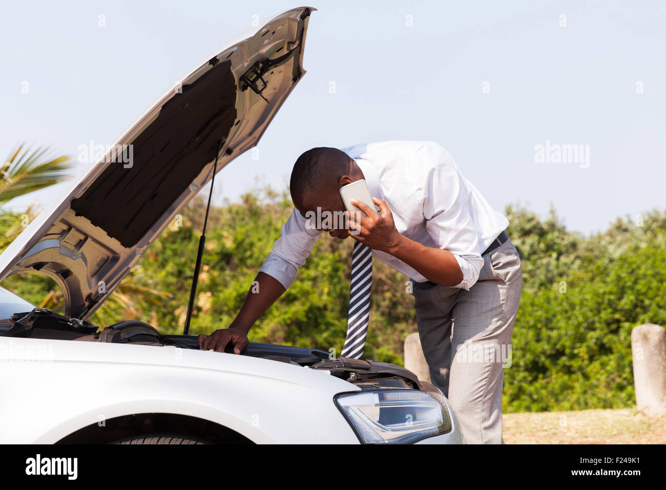 young man with broken down car with bonnet open calling for help Stock Photo