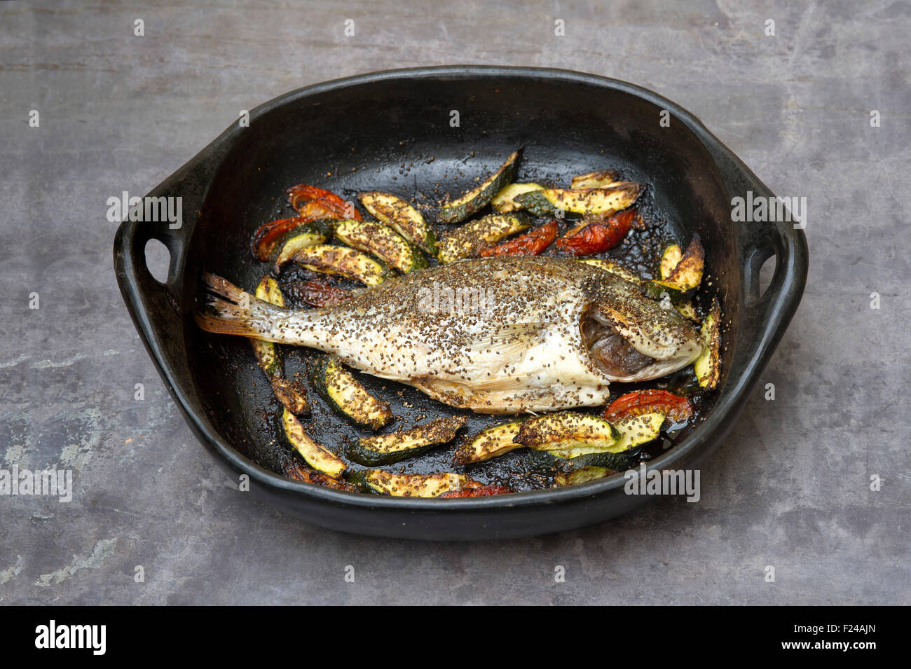 Paleo diet food, whole bream with chia, supposedly based on 'cave man' Palaeolithic foods for health, seen in a pan. a UK fish Stock Photo