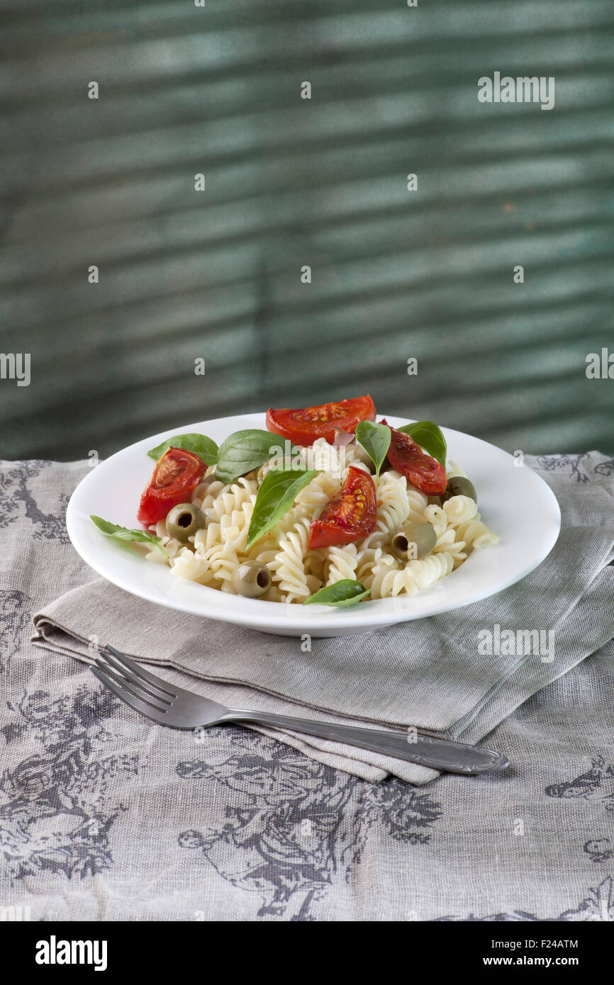 Pasta with baked tomatoes and green olives Stock Photo