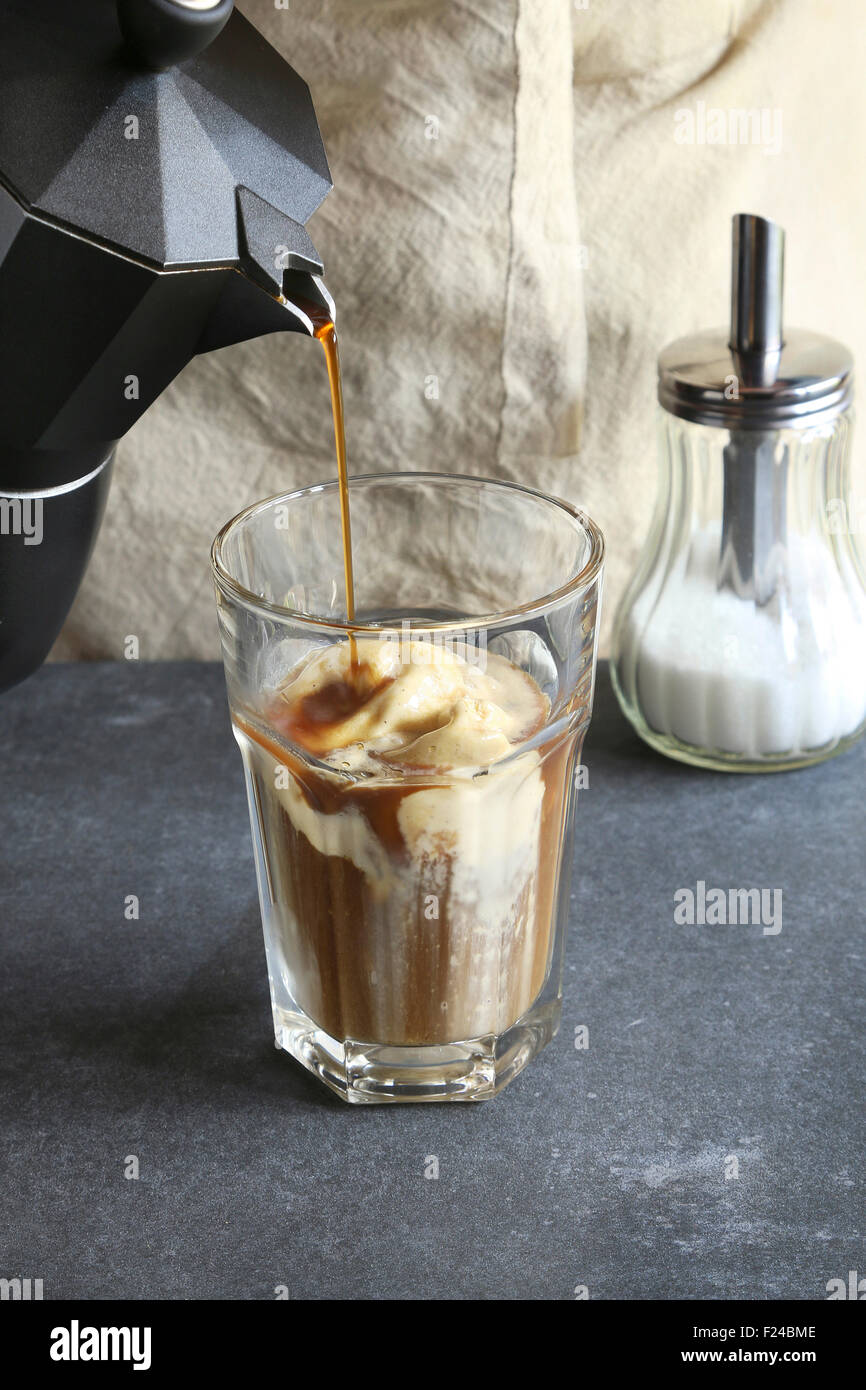 Pouring coffee in a glass over a dollop of ice cream Stock Photo