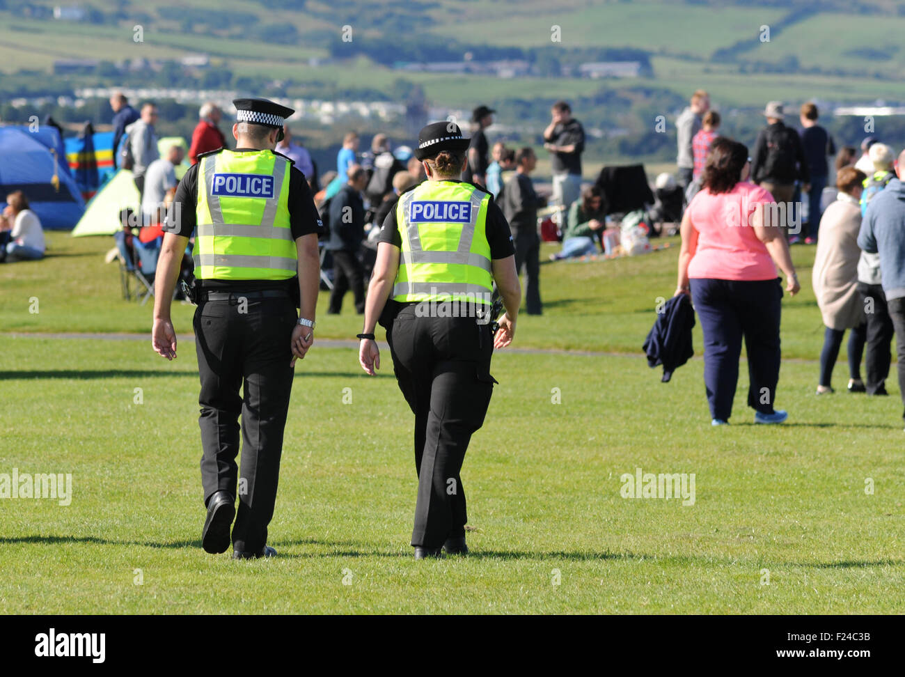 POLICE OFFICERS ON PATROL AT OUTDOOR EVENT FESTIVAL RE POLICING NUMBERS POLICEMEN OFFICER WALKING UNIFORM CUTS CRIMINAL  UK Stock Photo