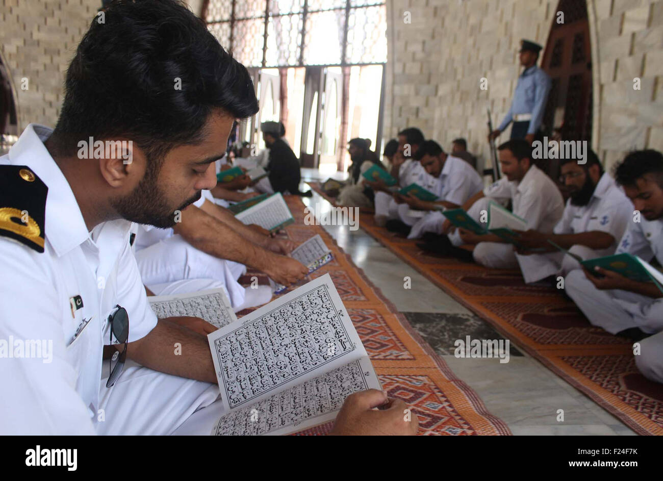 Pakistan Navy personnel are reciting Holy Quran for the departed soul of founder of Pakistan on the occasion of Quaid-e-Azam Muhammad Ali Jinnah's 67th death anniversary, at mausoleum in Karachi on Friday, September 11, 2015. Stock Photo