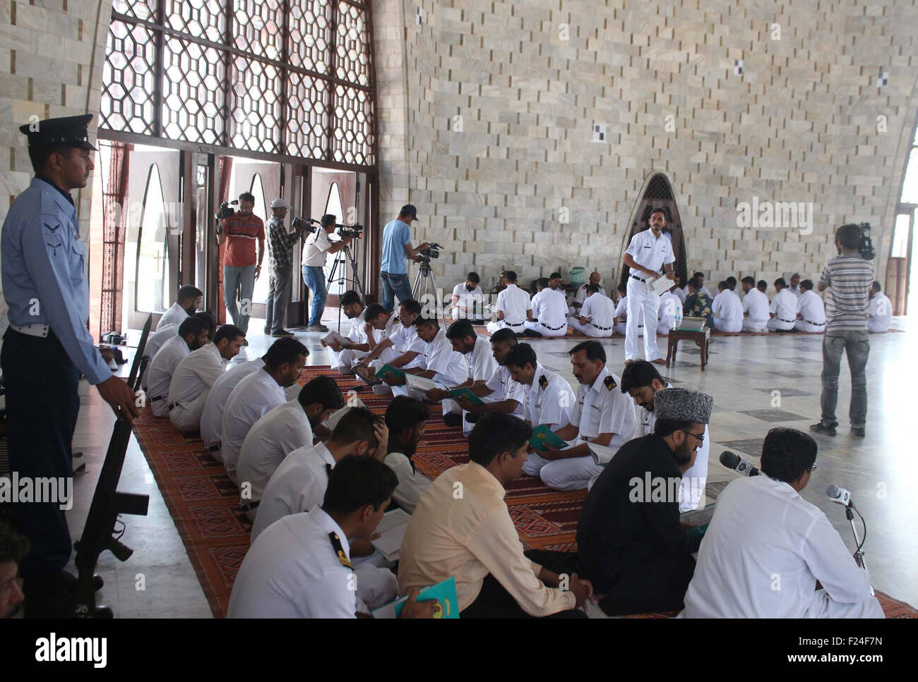 Pakistan Navy personnel are reciting Holy Quran for the departed soul of founder of Pakistan on the occasion of Quaid-e-Azam Muhammad Ali Jinnah's 67th death anniversary, at mausoleum in Karachi on Friday, September 11, 2015. Stock Photo