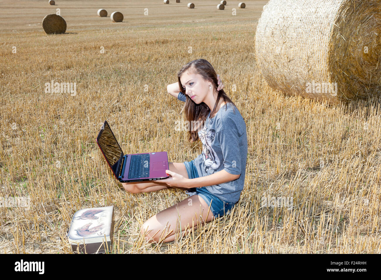Global communication, wireless technology in field, Teenage girl with laptop, Teen notebook, teenager Stock Photo