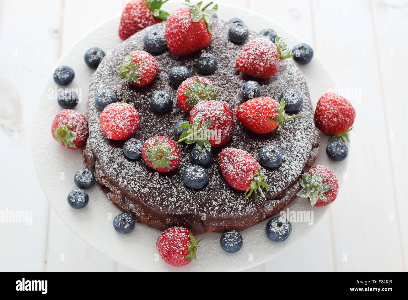 Chocolate cake with berries on top Stock Photo - Alamy