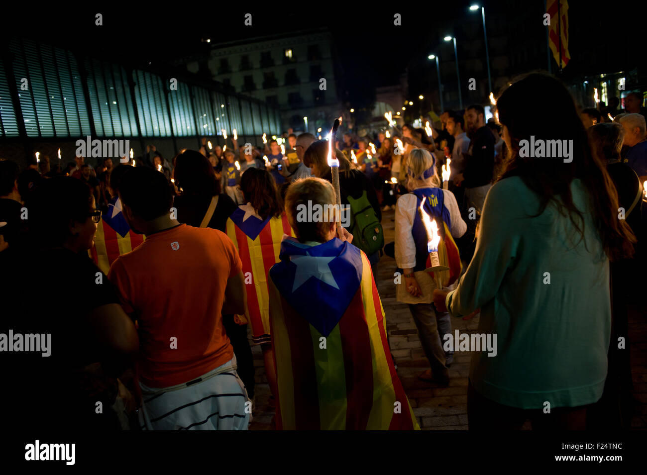 A group of independentists marches with torches and estelades (catalan independentist flag) in the streets of Barcelona. Stock Photo