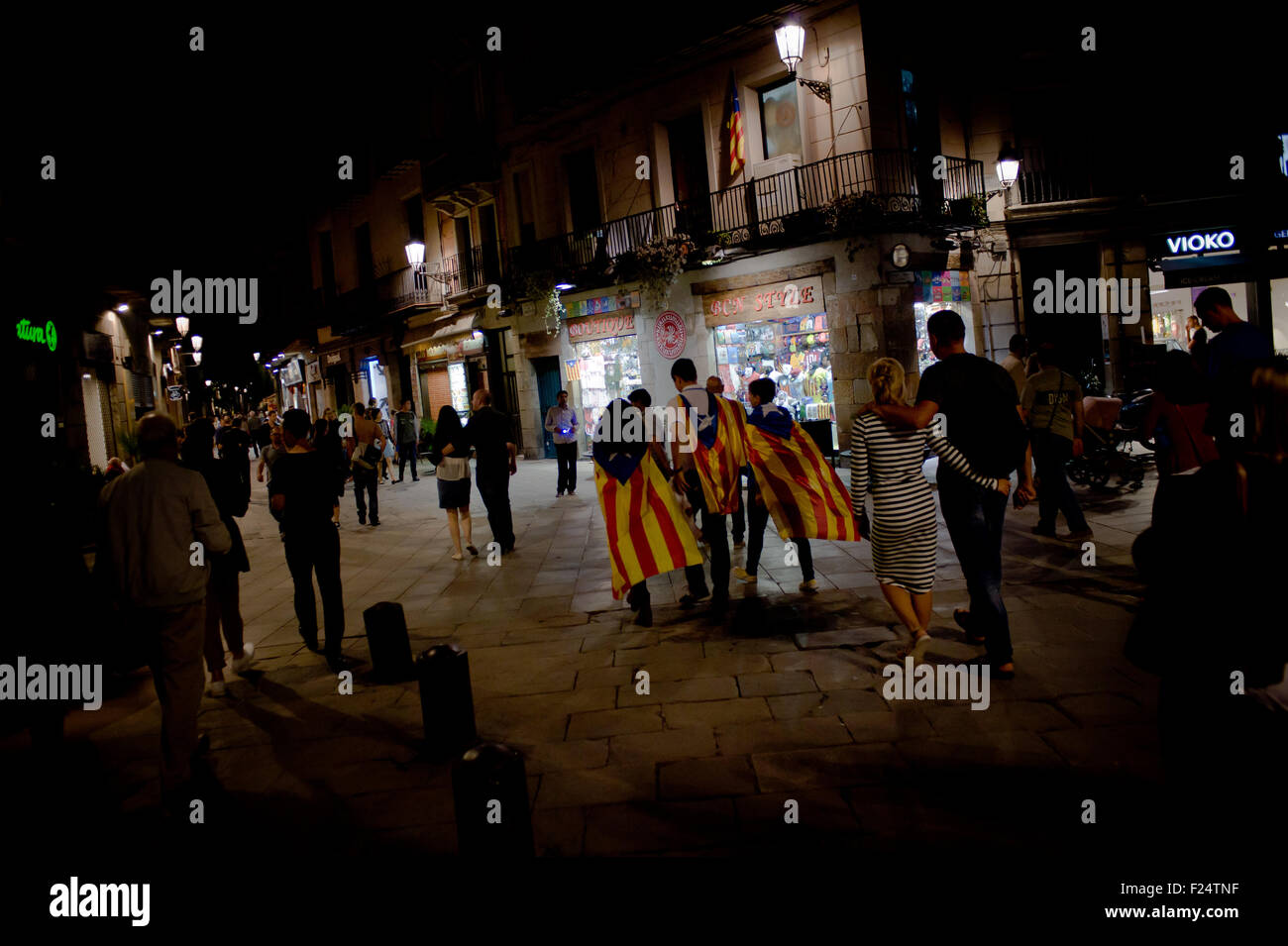 A group of people walks  wearing  estelades (catalan independentist flag)  by the streets of Barcelona. Stock Photo