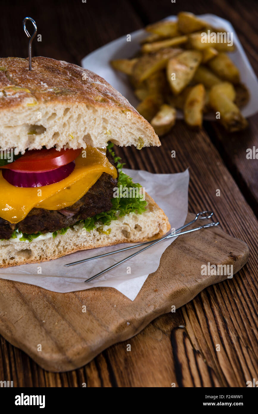 Homemade Ciabatta Burger with melted Cheese and homemade French Fries Stock Photo