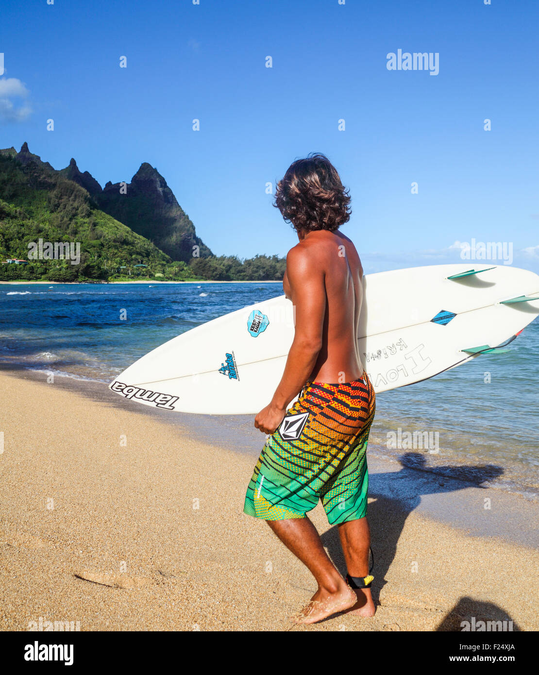 Surfer at Tunnels Beach on Kauai looks at Mt. Makana, called Bali Hai