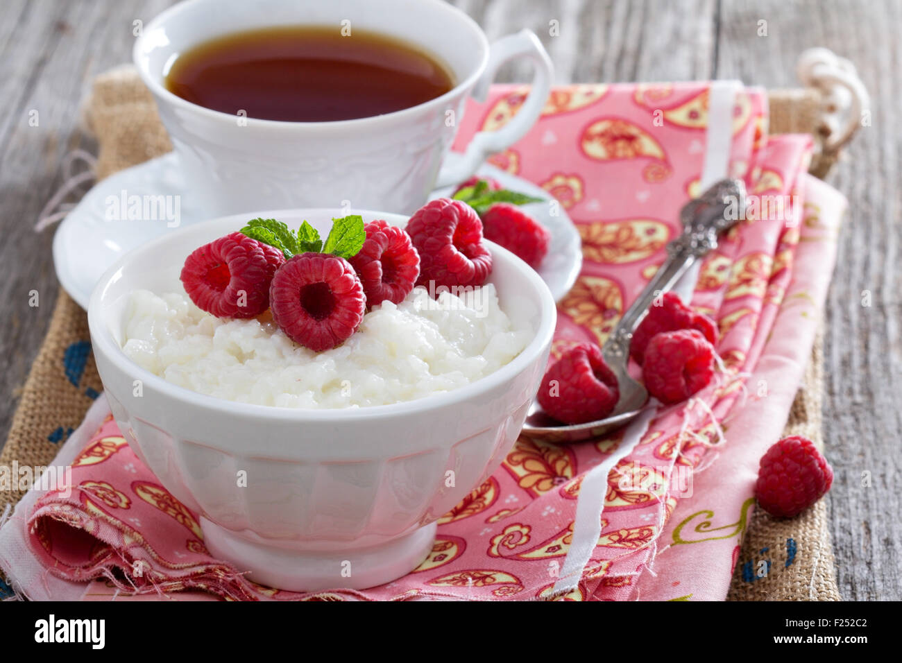 Rice pudding with raspberries and tea for breakfast Stock Photo Alamy