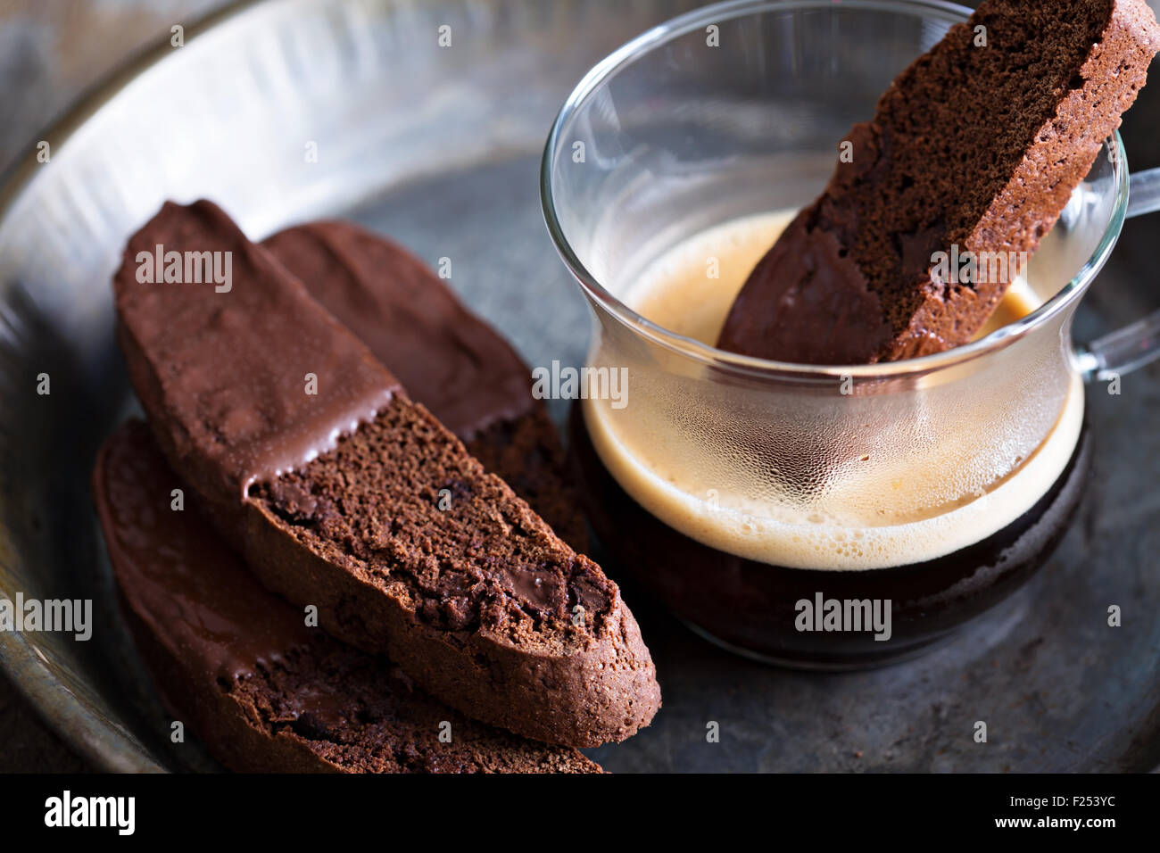 Chocolate biscotti cookies dipped in chocolate with a cup of coffee Stock Photo