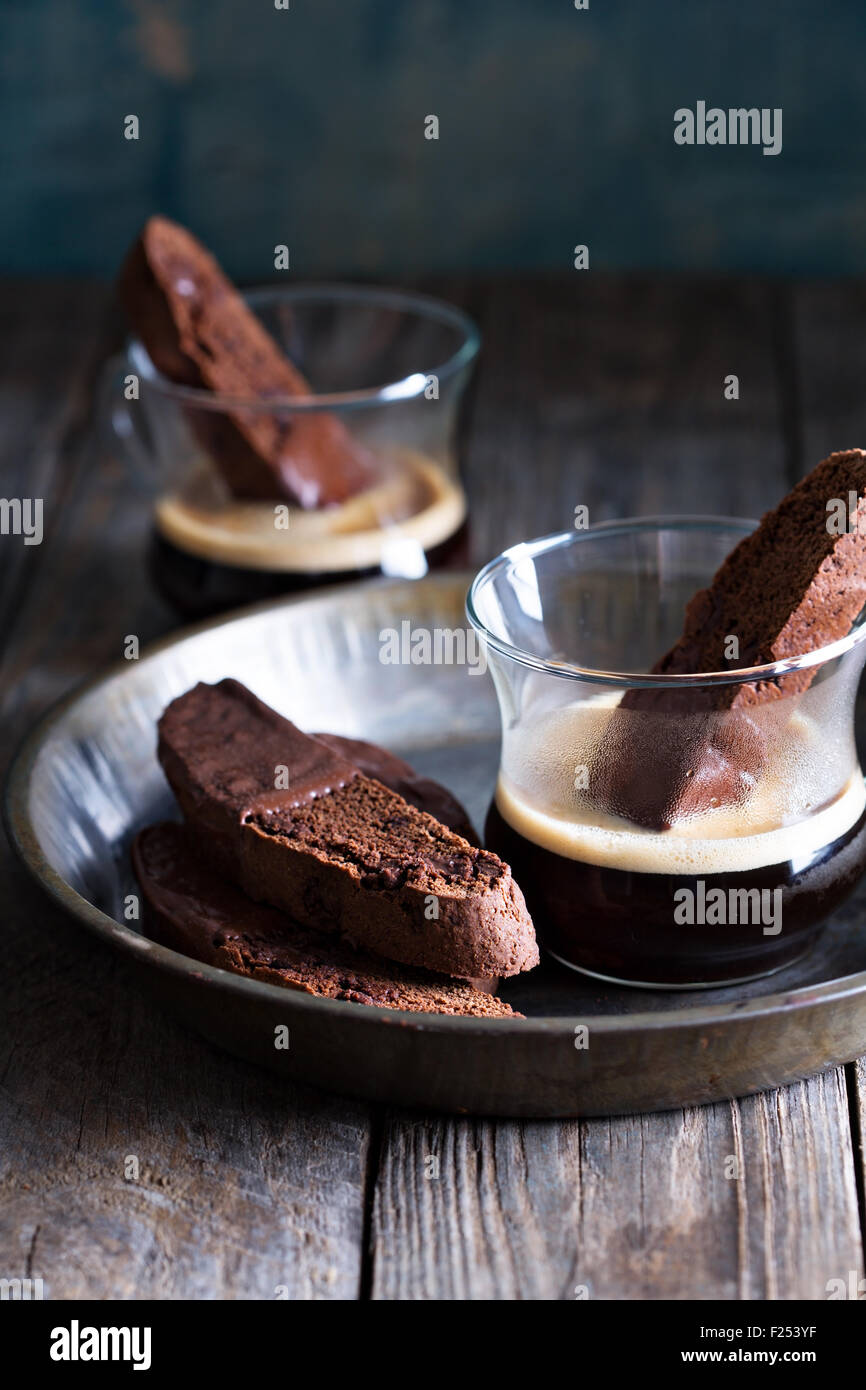 Chocolate biscotti cookies dipped in chocolate with a cup of coffee Stock Photo