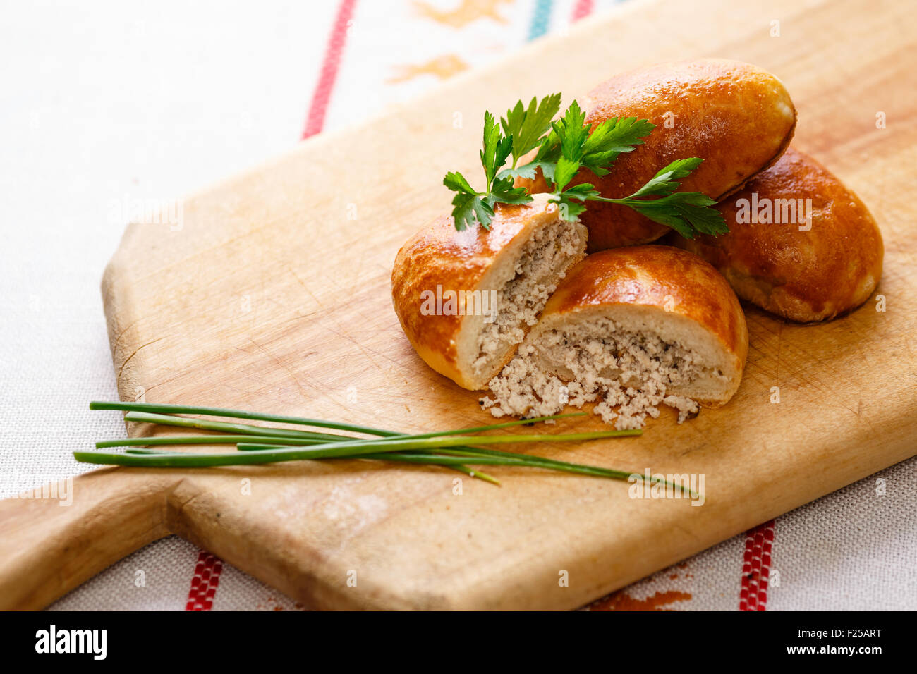 Russian pirozhki (baked patties) on wooden cutboard Stock Photo