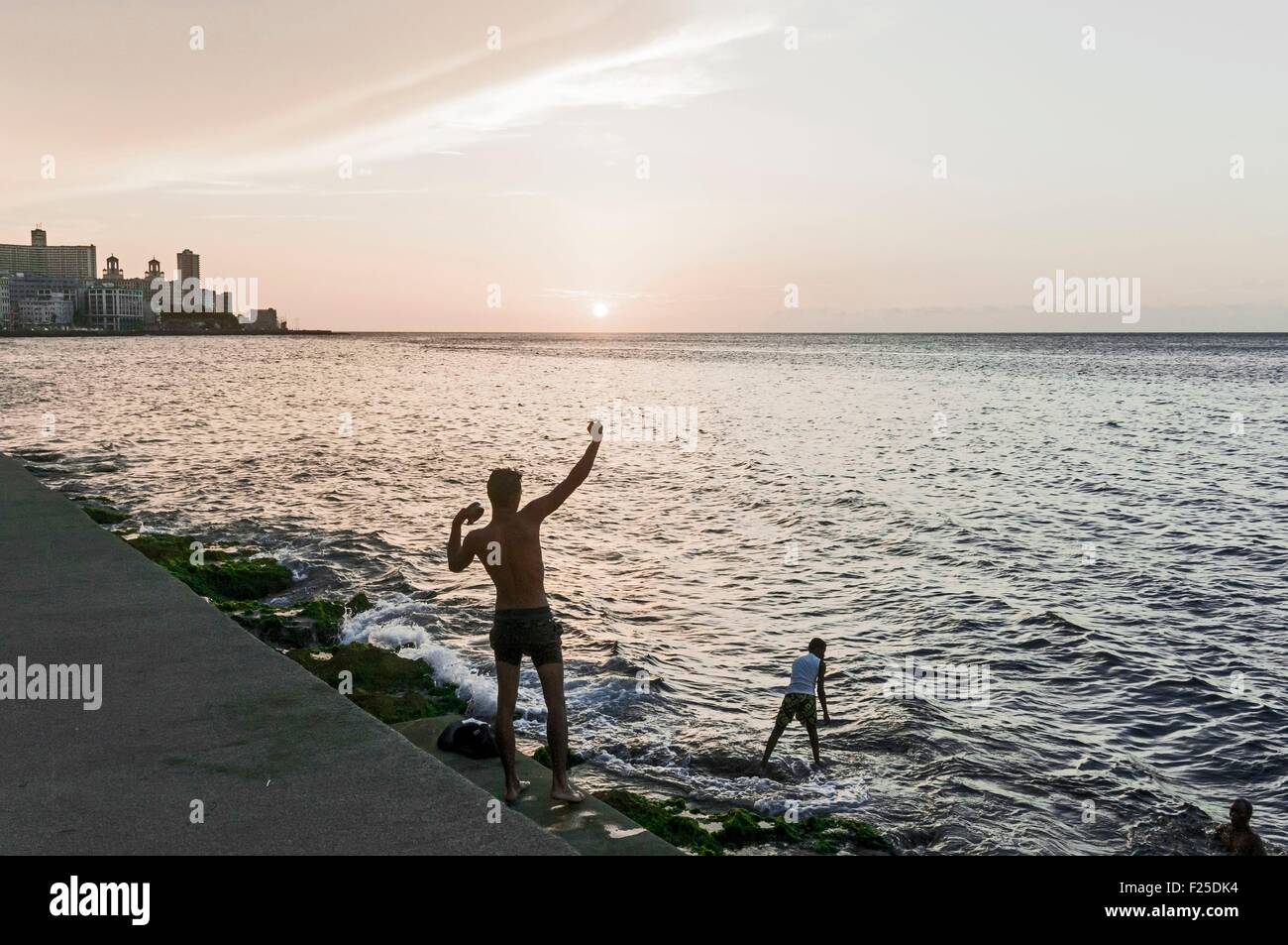 cuba-havana-fishermen-and-vedado-quarter-buildings-on-malecon-stock