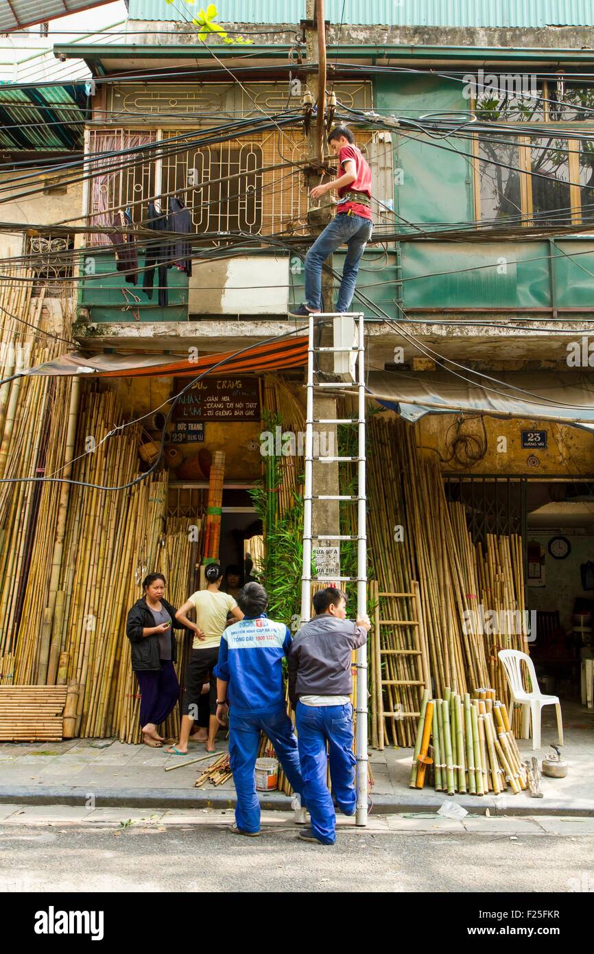 Vietnam, Hanoi, men repairing the electrical lines in the old city Stock Photo