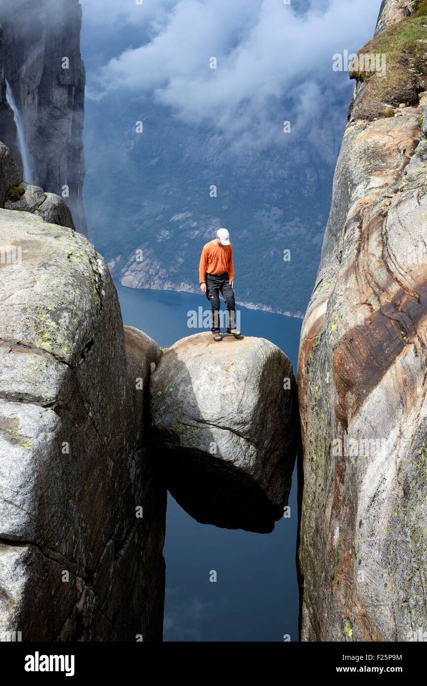 Norway, Rogaland, Lysefjord, Kjerag (Kiragg), hiker on Kjeragbolten (Kjerag Boulder), 1000m above the fjord Stock Photo