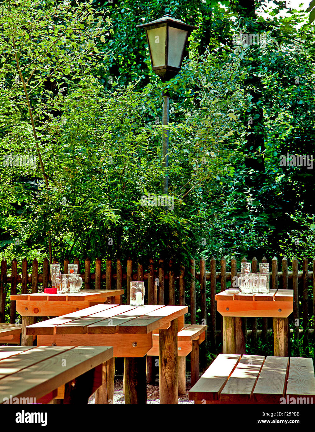 Munich, Germany - beer garden in a quiet moment at the end of a business day with empty beer glasses on wooden benches Stock Photo