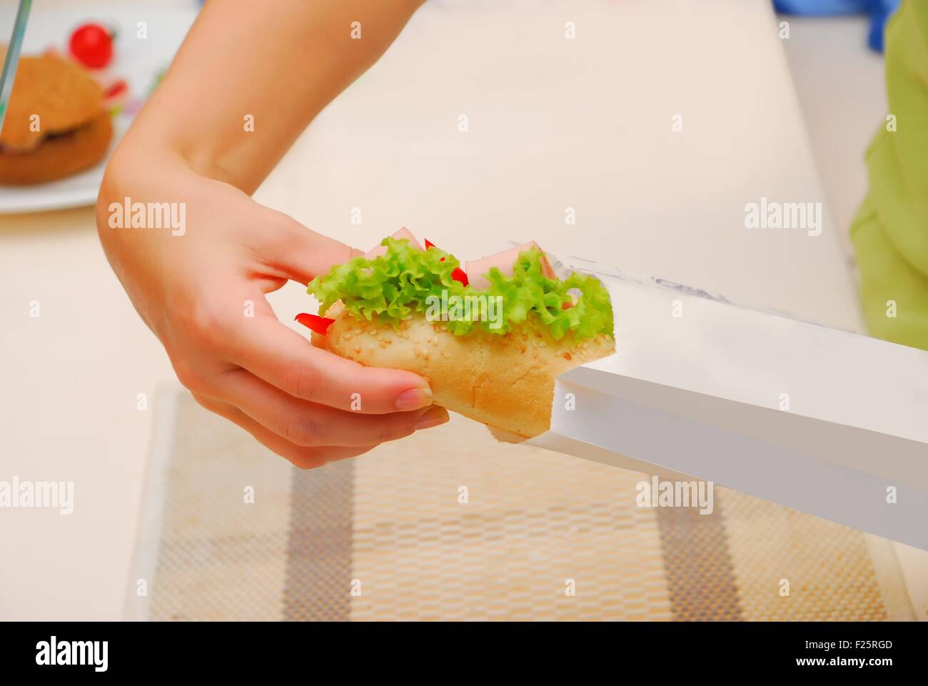 hands pack up submarine sandwich in paper bag at kitchen Stock Photo