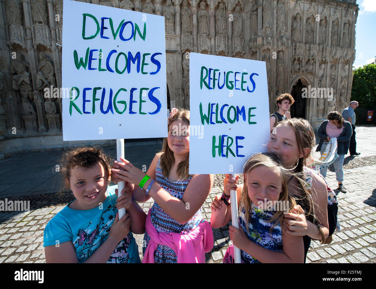 Exeter, Devon, UK. 12th Sep, 2015. Young girls hold up placards saying 'Devon Welcomes Refugees' during the Exeter Solidarity With Refugees Event outside the west front of Exeter Cathedral Credit:  Clive Chilvers/Alamy Live News Stock Photo