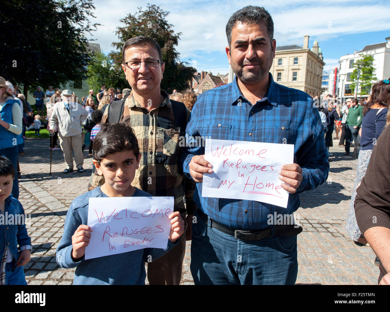 Exeter, Devon, UK. 12th Sep, 2015. Father and son hold up signs welcoming refugees to Exeter during the Exeter Solidarity With Refugees Event outside the west front of Exeter Cathedral Credit:  Clive Chilvers/Alamy Live News Stock Photo