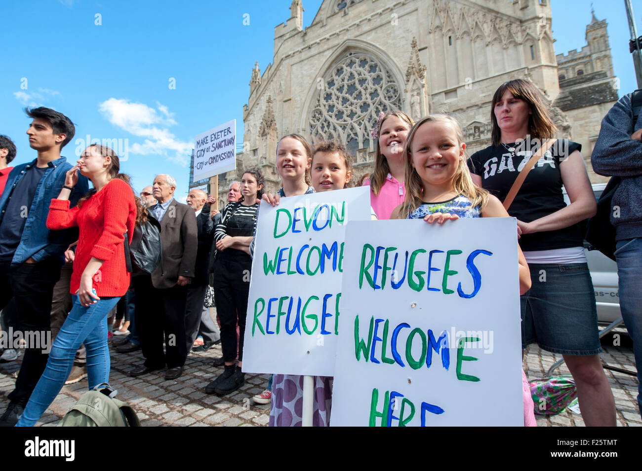 Exeter, Devon, UK. 12th Sep, 2015. Young girls hold up signs saying 'Devon Welcomes Refugees' during the Exeter Solidarity With Refugees Event outside the west front of Exeter Cathedral Credit:  Clive Chilvers/Alamy Live News Stock Photo