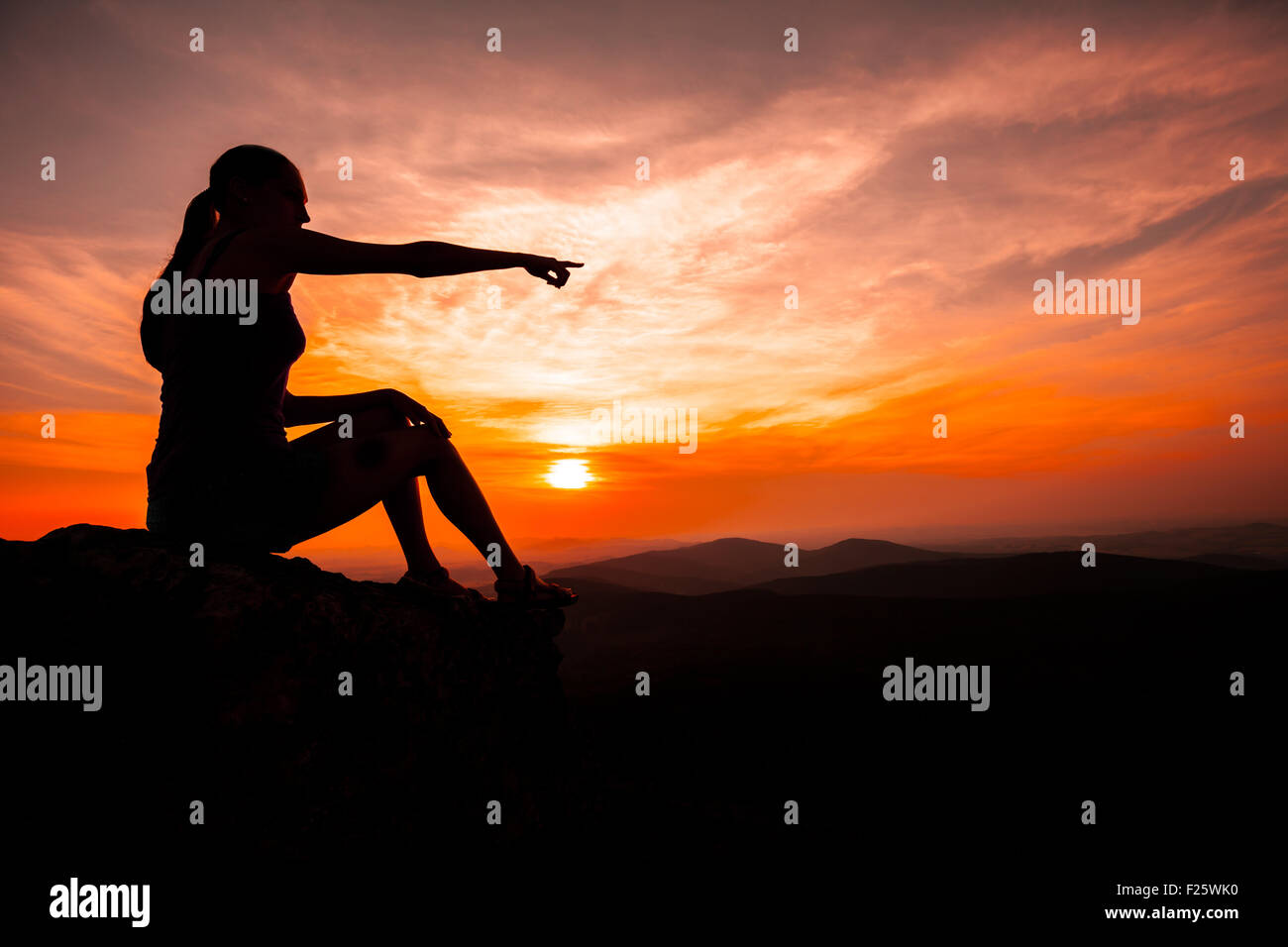 Silhouette of woman watching sunset and pointing Stock Photo - Alamy