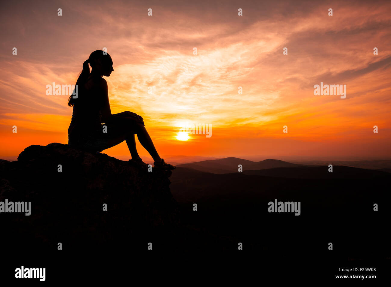 Silhouette of woman watching sunset Stock Photo - Alamy