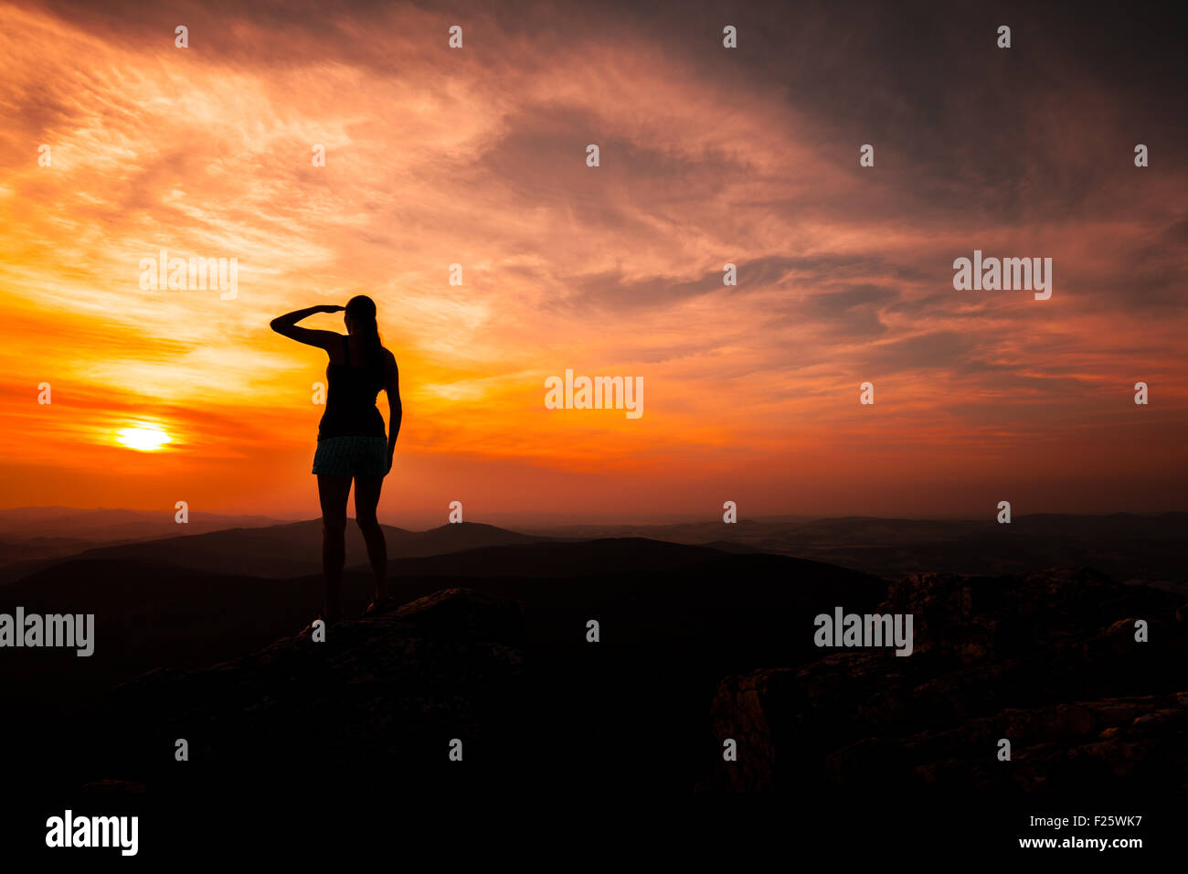 Silhouette of woman watching sunset Stock Photo - Alamy