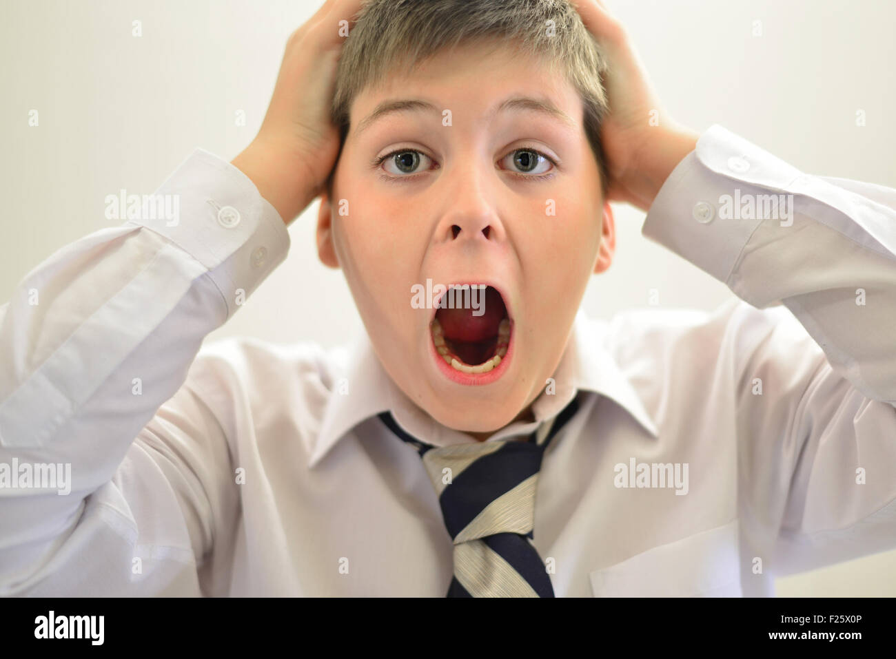Teen boy screaming holding his hands behind  head Stock Photo